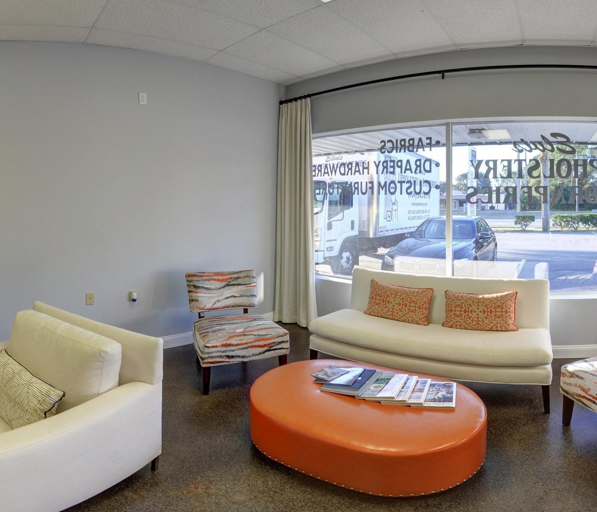Inside the Elvis Upholstery showroom in Atlantic Beach FL, with fabric books, custom seating and drapery on display